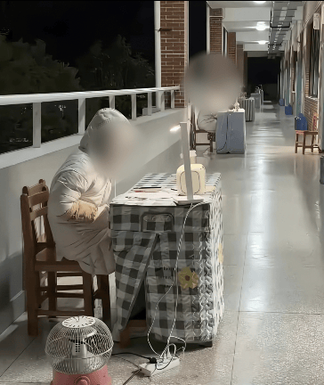 大冷天柳州一学校老师摆桌子坐在走廊为学生答疑引争议：折腾老师